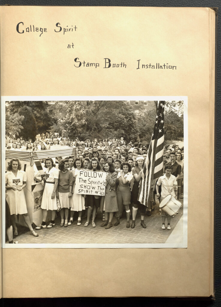 Page with text "College Spirit at Stamp Booth Installation." Under text is an image of MWC students holding up a sign that says "Follow the spirit of 76 show the spirit of 42."